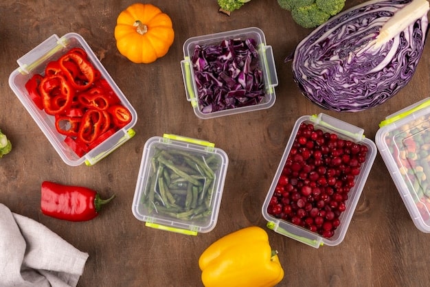 A close-up shot of a reusable container filled with neatly organized, pre-cut vegetables and fruits, such as carrot sticks, cucumber slices, and grape tomatoes, arranged for easy snacking and meal preparation.
