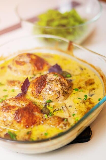 A close-up shot of a steaming one-pot lemon herb chicken and rice dish, showcasing the golden-brown chicken, vibrant herbs, and perfectly cooked rice, all glistening with a light lemon sauce.