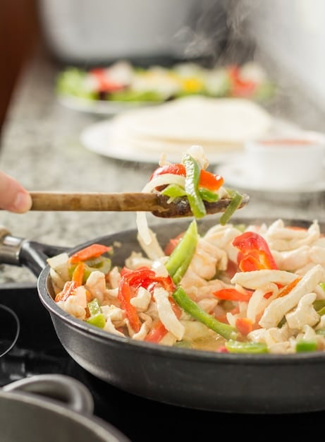 A close-up shot of a colorful vegetarian stir-fry being prepared in a wok, with various fresh vegetables and tofu.