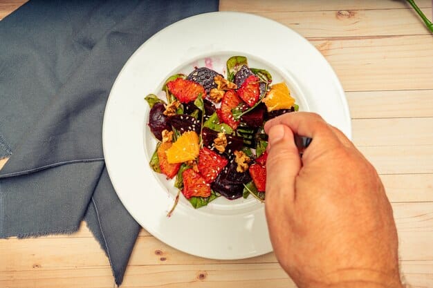 A close-up shot of hands tossing a vibrant salad made with leftover roasted vegetables (such as bell peppers, zucchini, and onions) and grilled halloumi cheese. The salad is dressed with a light vinaigrette, and there are fresh herbs sprinkled on top, illustrating a quick and healthy way to use leftovers.