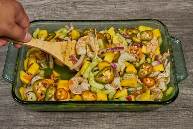 A sheet pan filled with blackened shrimp coated in Cajun seasoning, alongside colorful bell peppers and red onions. The photo highlights the smoky char on the shrimp and vegetables, suggesting a spicy and flavorful meal.
