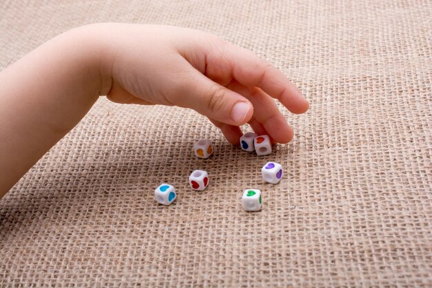 A close-up shot of a child's hands carefully moving a game piece on a detailed board game. The game board features colorful illustrations and various strategic pathways. The lighting is soft and focused, highlighting the child's concentration and engagement with the game.