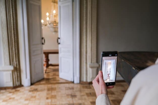 A close-up shot of a person's hands installing a wireless door sensor on a door frame, with a smartphone nearby displaying the configuration settings for the sensor.