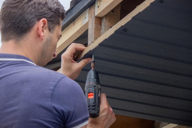 A partially completed dog house with the frame and walls assembled. A person is attaching the roof with a drill.