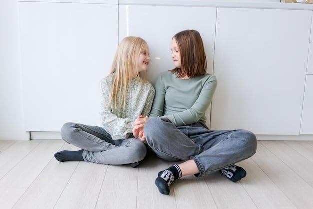 A mother is kneeling down and talking to her young daughter, who looks upset. The mother is making eye contact and listening attentively, providing comfort and support. The scene is set in a cozy living room, creating a safe and nurturing environment.