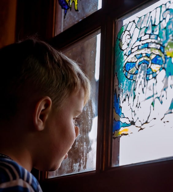A child drawing a picture with crayons, expressing their feelings after hearing about a tragic news event. The drawing depicts a sad scene, but the child is focused and engaged in the activity.