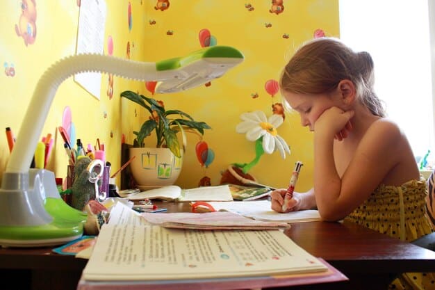A child sitting at a desk, surrounded by colorful markers, notebooks, and diagrams, deeply focused on creating a mind map or a detailed drawing related to a lesson.