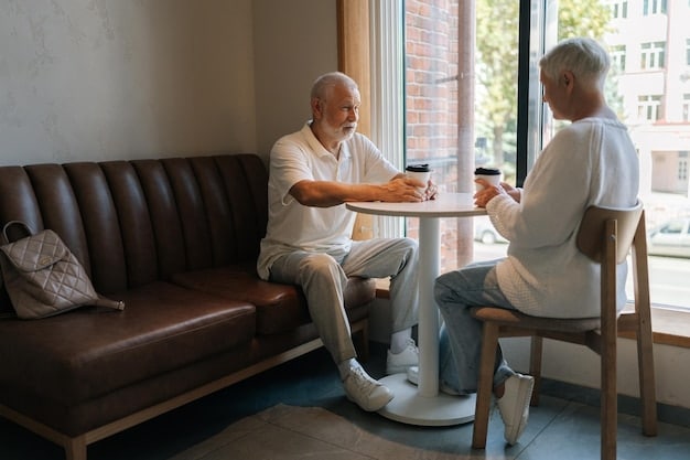 An elderly man sitting in a comfortable chair, with a healthcare professional explaining paperwork to him. They are both smiling and engaged in a positive conversation in a well-lit living room.