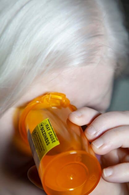 A close-up shot of a medication label, clearly showing the dosage instructions, expiration date, and warnings. The background is blurred to focus attention on the label details.