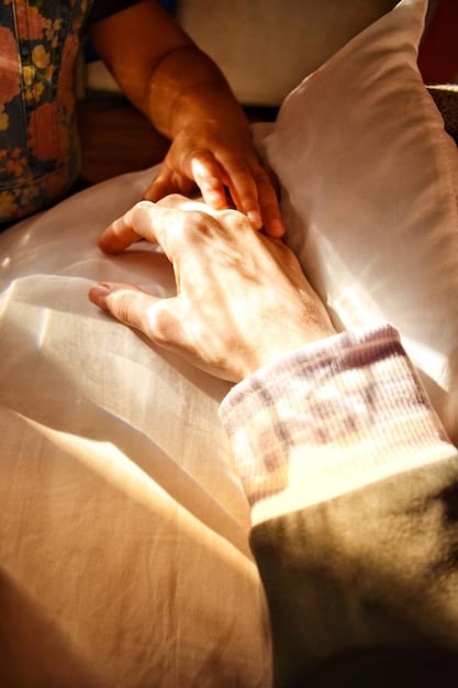 A serene image of a hospice nurse holding the hand of an elderly patient in a warmly lit room, symbolizing compassion and care.