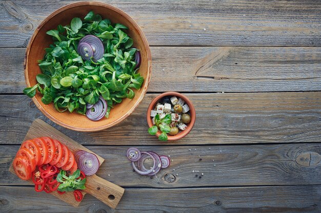 A close-up shot of various iron-rich foods displayed on a wooden cutting board, including spinach, lentils, red meat (beef), and fortified cereals. The arrangement emphasizes the diversity of food sources for obtaining iron in a balanced diet.