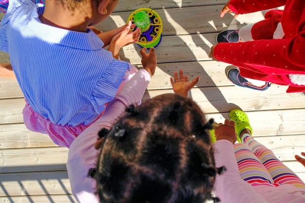 A group of children playing happily in a well-organized and safe outdoor playground at a childcare center, supervised by attentive caregivers.