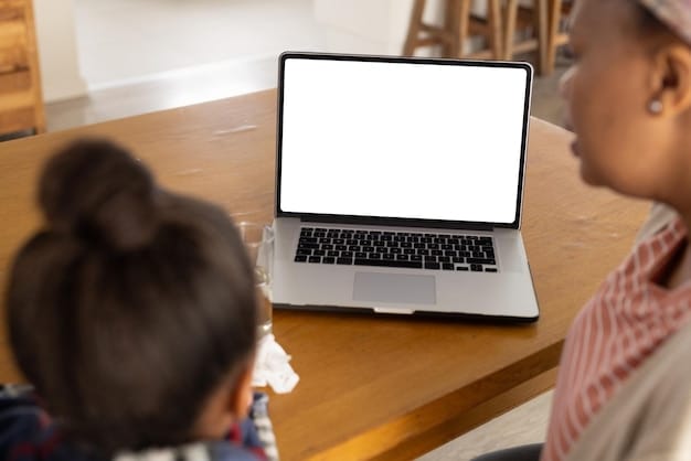 A parent sitting at a desk, looking at a laptop screen displaying a website with information about special needs childcare resources, with a child with special needs sitting beside them, pointing at the screen.