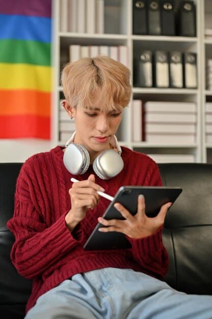A young adult with autism using a tablet with a specialized app designed for communication, featuring visual supports and text-to-speech functionality. The person is smiling and engaged with the device.