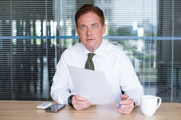 A professional advisor sitting at a table in an office, discussing documents with a concerned parent who is exploring options for their child with special needs. The atmosphere is supportive and focused on financial planning.