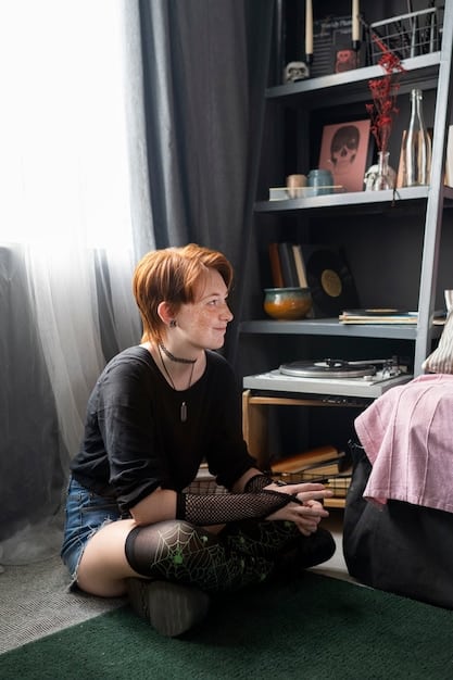 A young adult with autism is sitting in a quiet room lit by natural light and wearing noise-canceling headphones while working on a puzzle. The room is organized and uncluttered, filled with sensory supports.