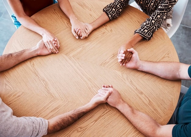 A close-up shot of a support group meeting. Hands are placed in the center of the table, symbolizing unity and shared experience. The atmosphere is warm and inviting.